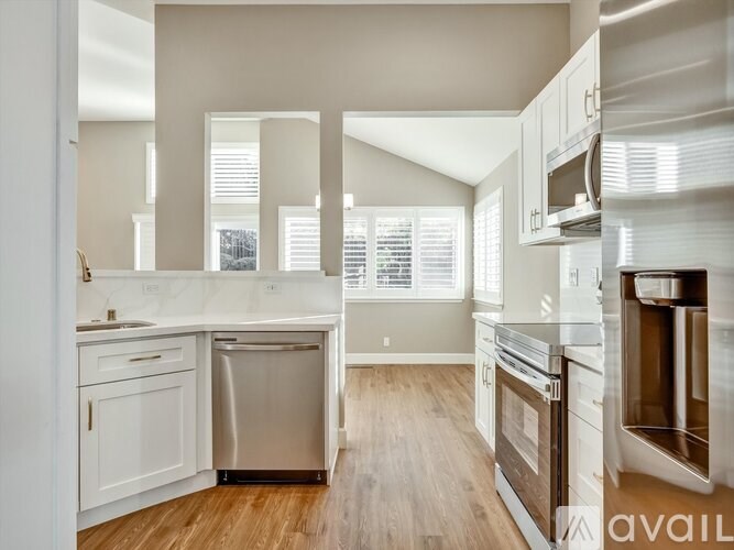A modern kitchen with stainless steel appliances and white cabinets.