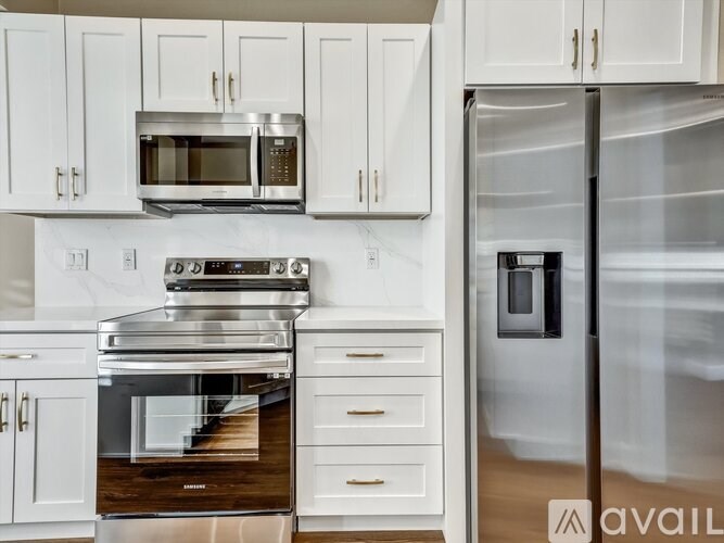 A modern kitchen with white cabinets and stainless steel appliances.