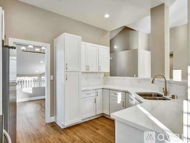 A modern kitchen with white cabinets and a marble countertop.