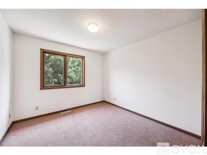 A room with a window and carpeted floor.