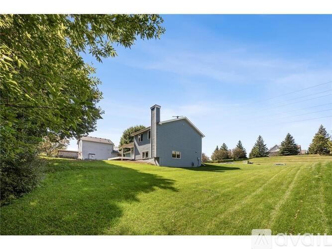 A house with a chimney is surrounded by a green lawn.