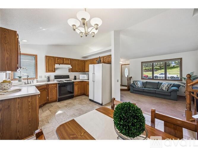 A well-lit kitchen with wooden cabinets and a white refrigerator.