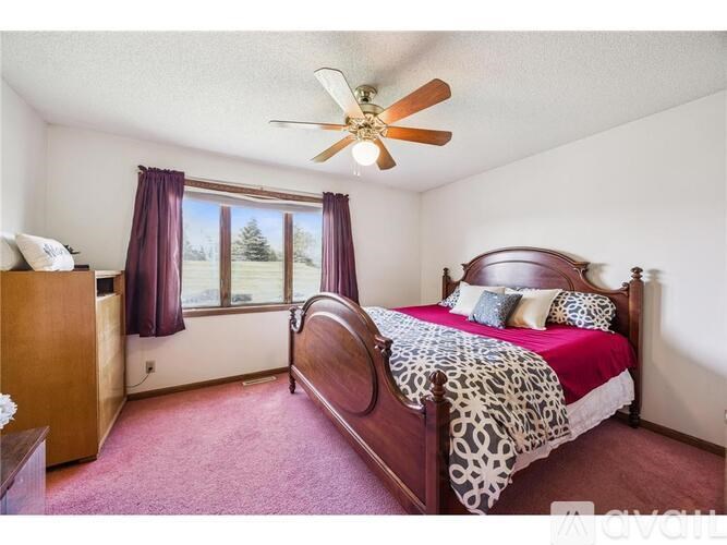 A bedroom with a leopard print bedspread and a ceiling fan.