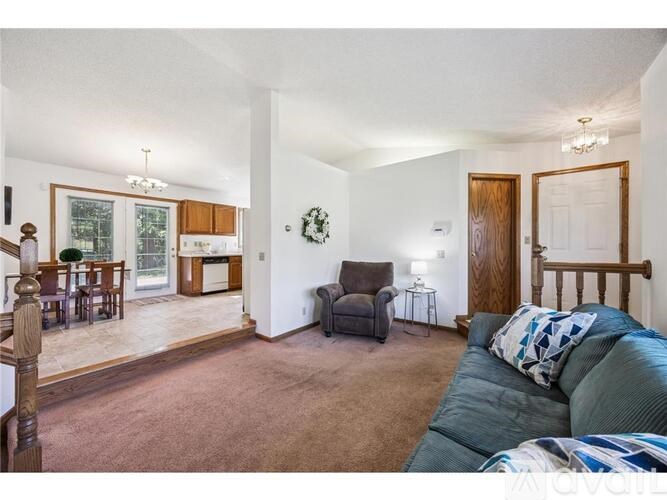 A living room with a couch, chair, and a dining table.