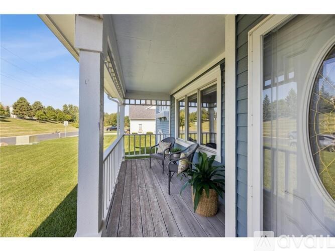 A porch with a white railing and a potted plant.