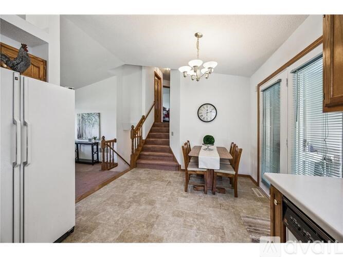 A kitchen with a dining table and chairs in the middle of the room.
