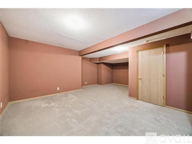 A room with a carpeted floor and a wooden door.