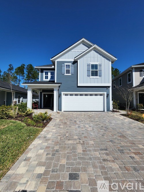 A house with a grey front yard and a driveway.