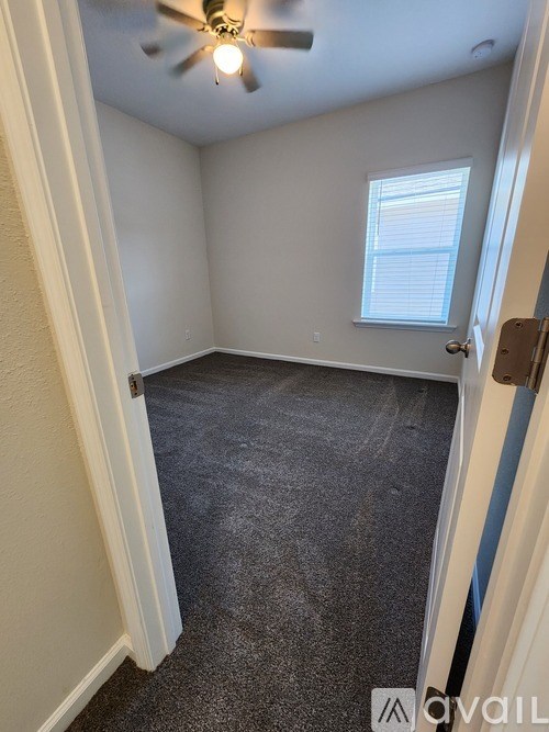 A room with a ceiling fan and a window.