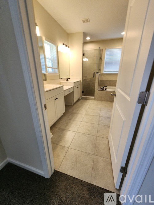 A bathroom with a sink, mirror, and shower.
