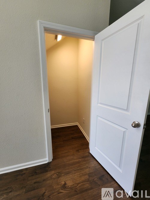 A white door is open to a room with a light on.