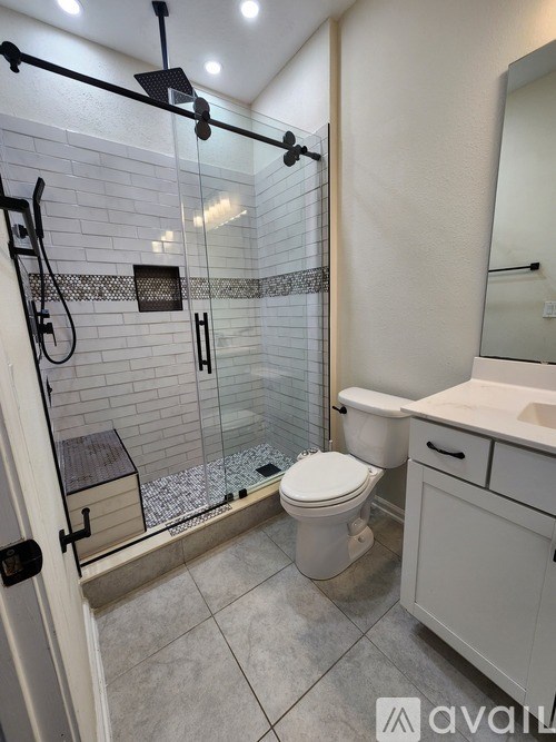 A bathroom with a toilet, sink, and shower.