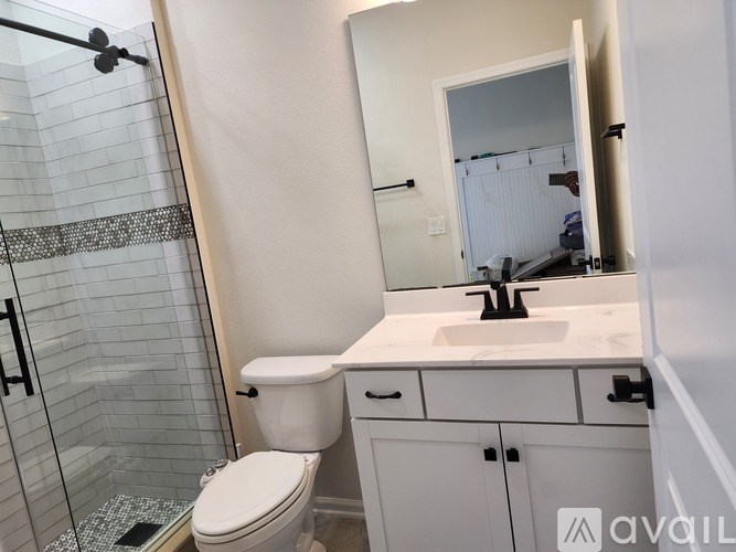 A white toilet sits next to a sink in a bathroom.