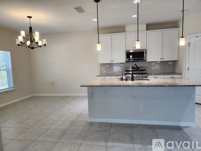 A kitchen with a marble countertop and a chandelier.