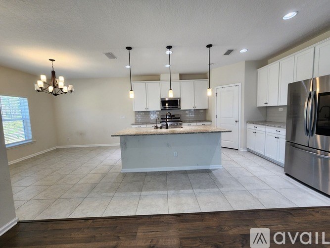A kitchen with a center island and stainless steel appliances.