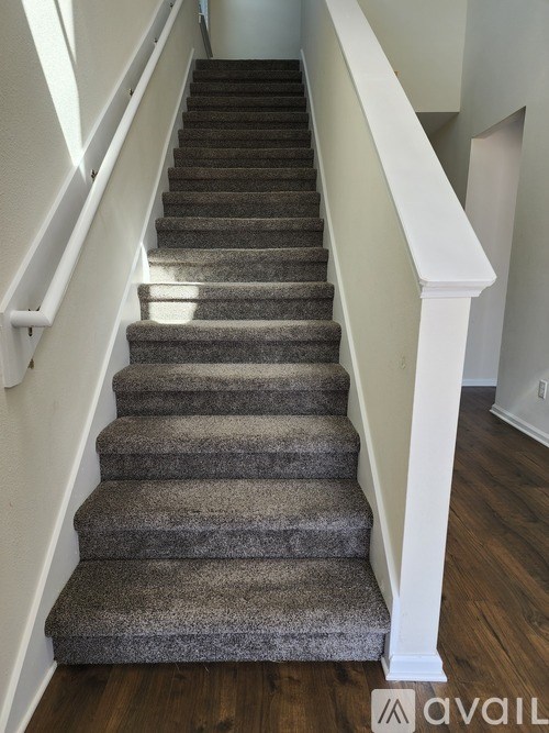 A staircase with a carpeted runner and white balusters.