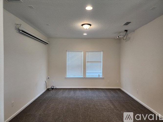 A room with a window and carpeted floor.