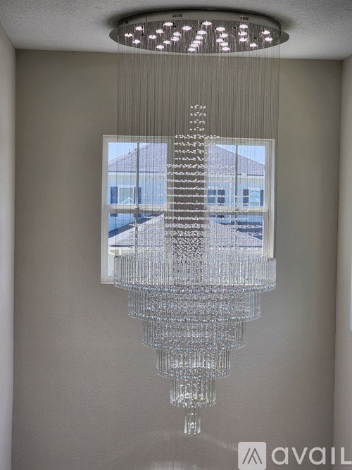A large chandelier with a rectangular window in the middle of it.
