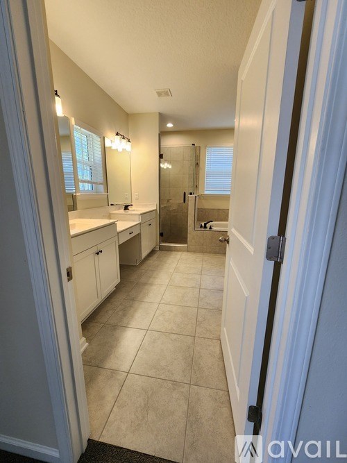 A bathroom with a white vanity and a white door.