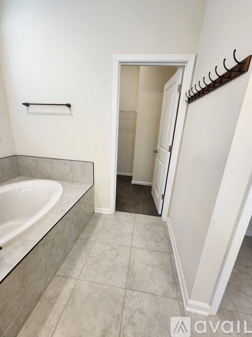A bathroom with a tub and a towel rack.