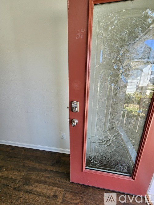 A red door with a glass window and a handle.
