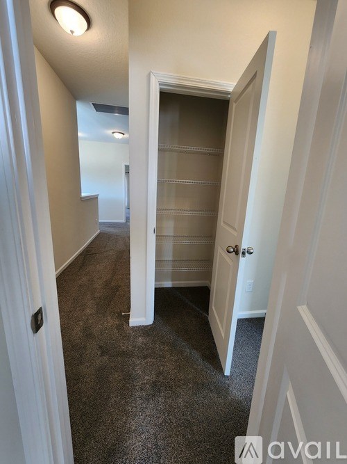 A hallway with a door on the right and a carpeted floor.