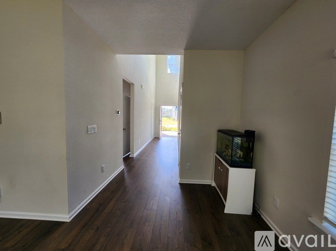 A room with a fish tank and wooden floors.