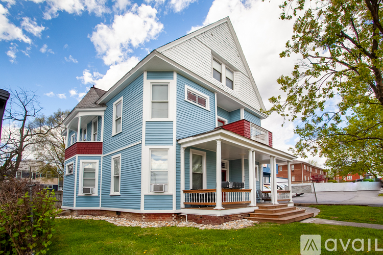 A blue house with a white porch and a sign that says "available".