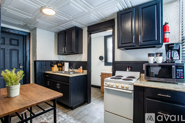 A kitchen with black cabinets and a white stove top oven.