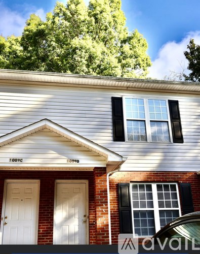 A house with a white front door and a window with black shutters.