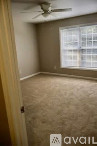 A room with a ceiling fan and a window.