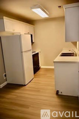 A kitchen with a white fridge and a white cabinet.