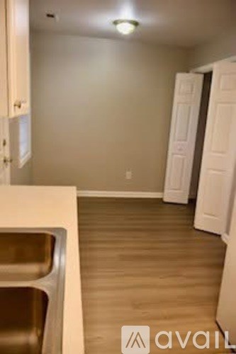 A kitchen with white cabinets and a white door.