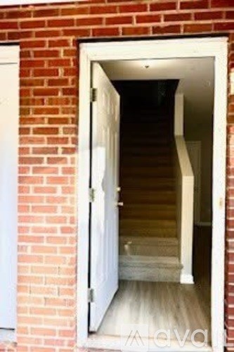 A small white door is open to a stairway.