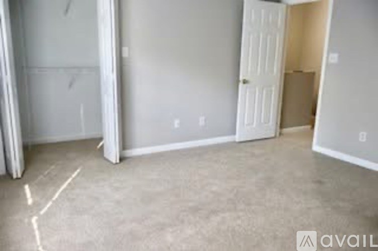 A room with a white door and a wall socket.