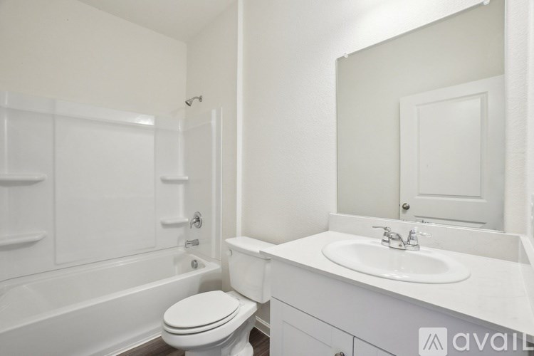 A white bathroom with a toilet, sink, and bathtub.