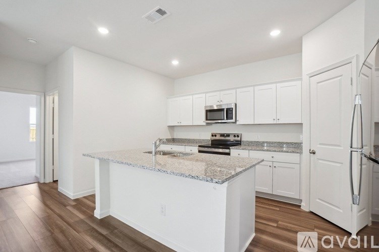 A kitchen with a granite countertop and white cabinets.