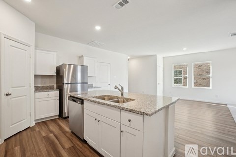 A kitchen with white cabinets and a granite countertop.
