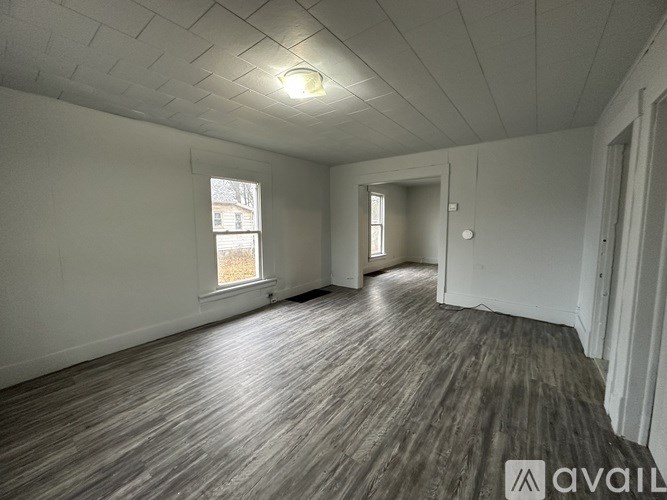 A room with wooden flooring and a window.