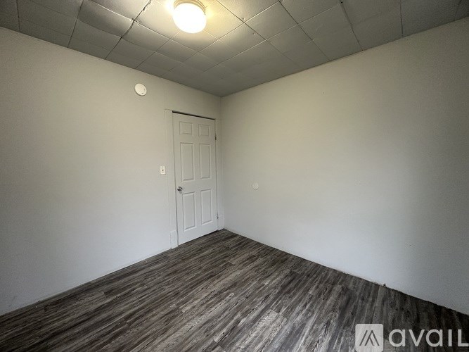 A room with a wooden floor and a white door.