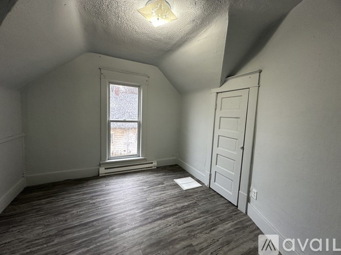 A room with a window and a door is available for rent.