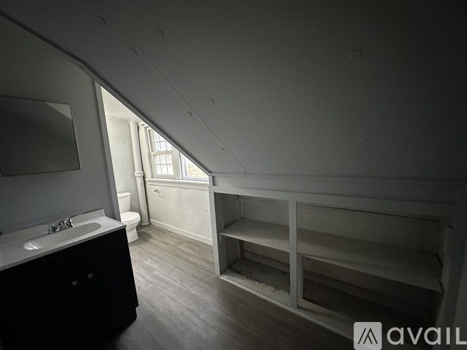 A bathroom with a sink, toilet, and window.