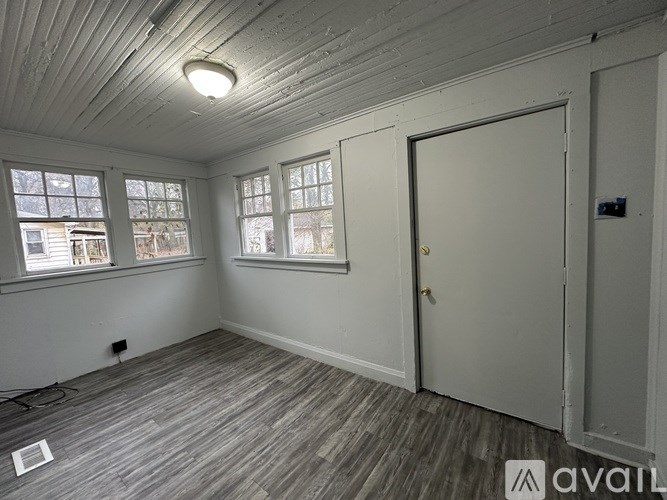 A room with a door, windows, and a ceiling light.