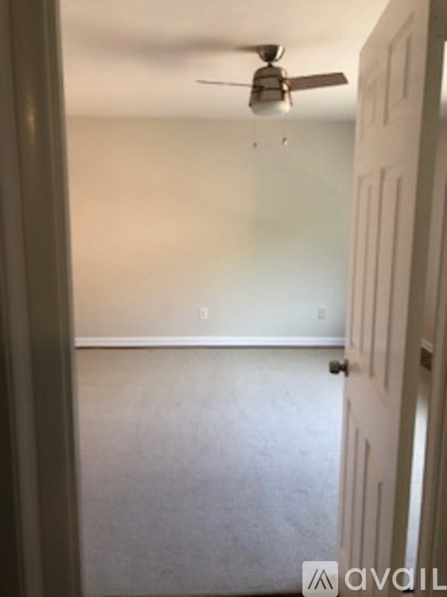 A room with a ceiling fan and a closed door.