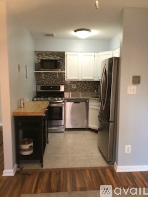 A kitchen with a refrigerator, oven, and microwave.