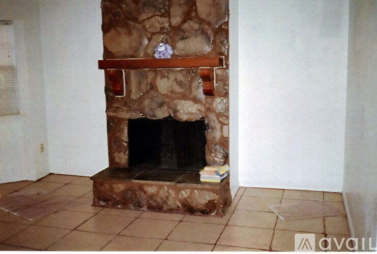 A stone fireplace with a clock on the mantle.