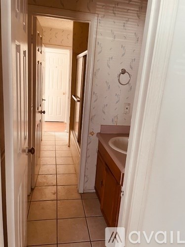 A bathroom with a white door and a white wallpapered door.