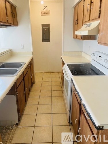 A kitchen with tile flooring and white appliances.