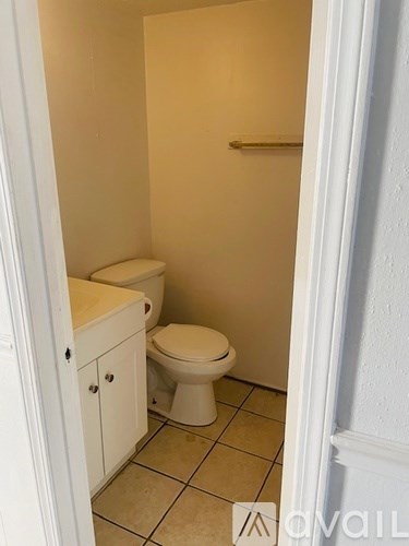 A small bathroom with a toilet and a cabinet.