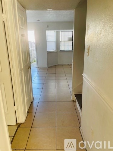 A hallway with tiled floors and white doors.